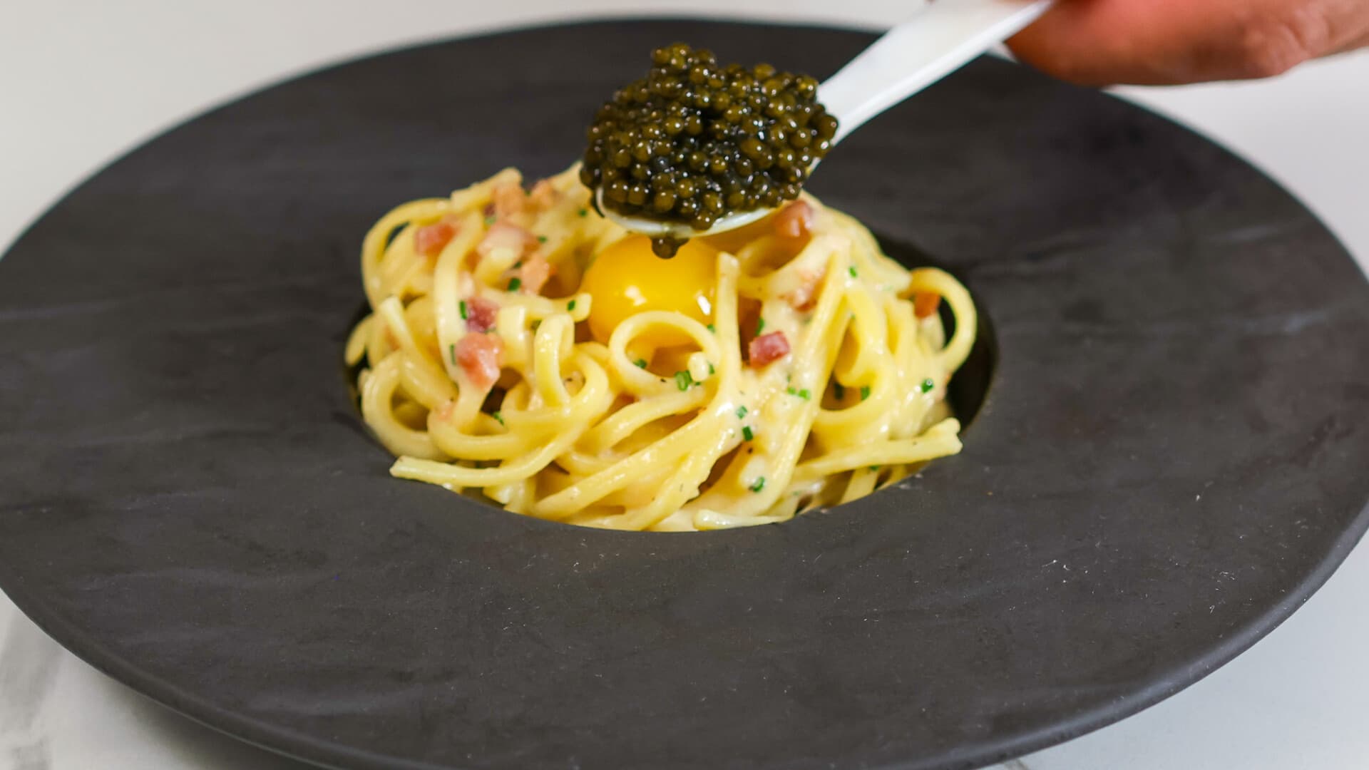Spaghetti carbonara plated with egg yolk