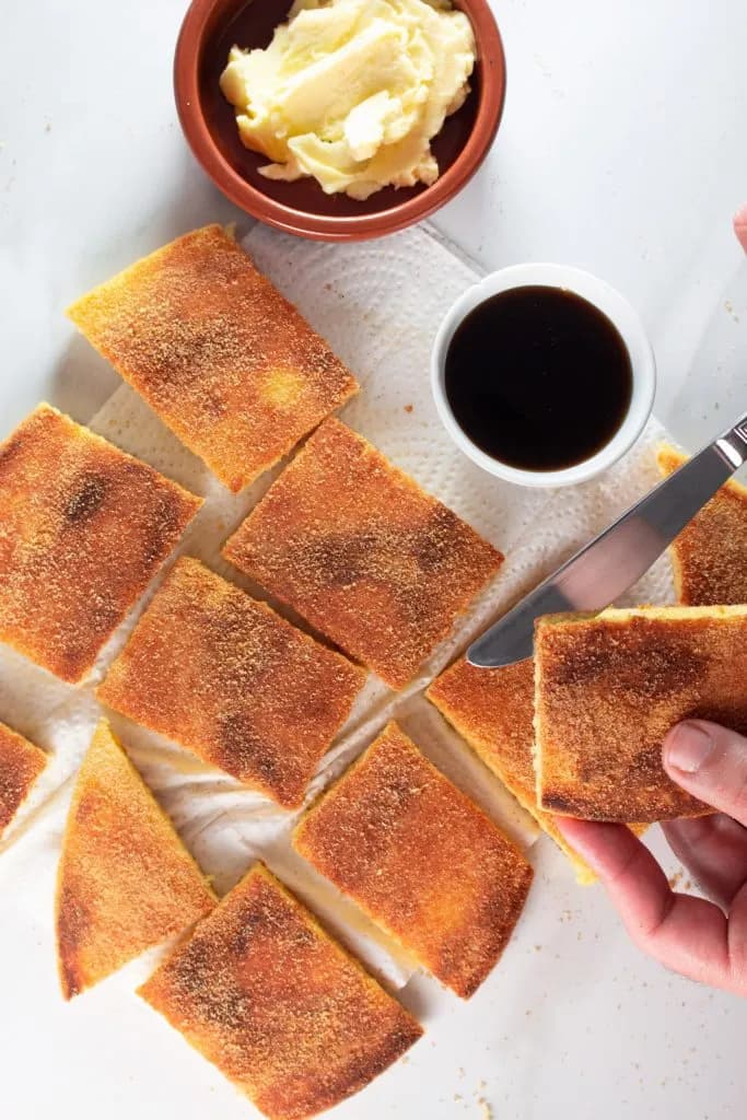 Harcha semolina bread cut into squares with butter and coffee