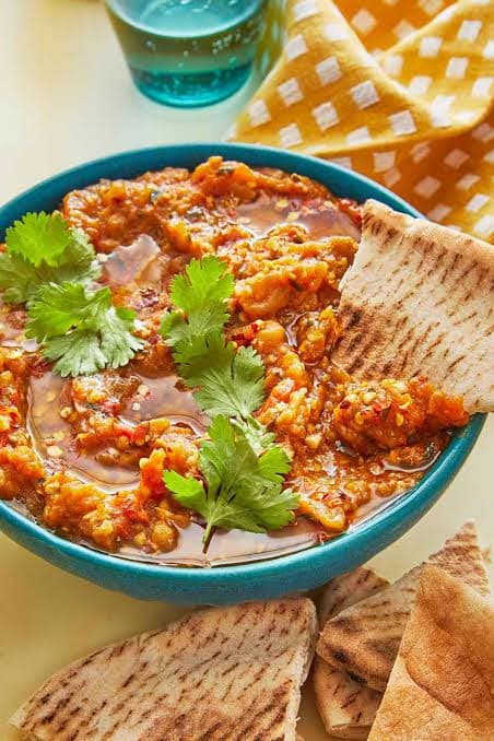 Zaalouk eggplant and tomato dip garnished with lemon and herbs